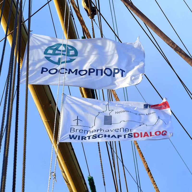 Zwei Werbeflaggen an einem Mast, wehend im Wind.