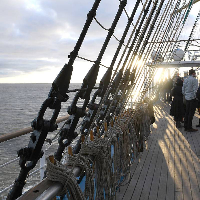 Deck eines Segelschiffes bei Fahrt mit Sonnenstrahlen zwischen den Tauen hindurch