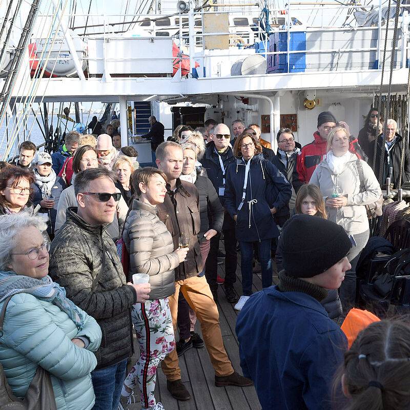 Menschengruppe auf Deck eines Segelschiffes