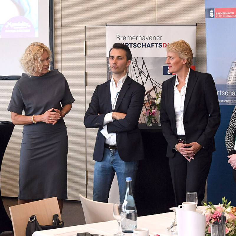 Redner und Moderatorin stehen gemeinsam auf der Bühne