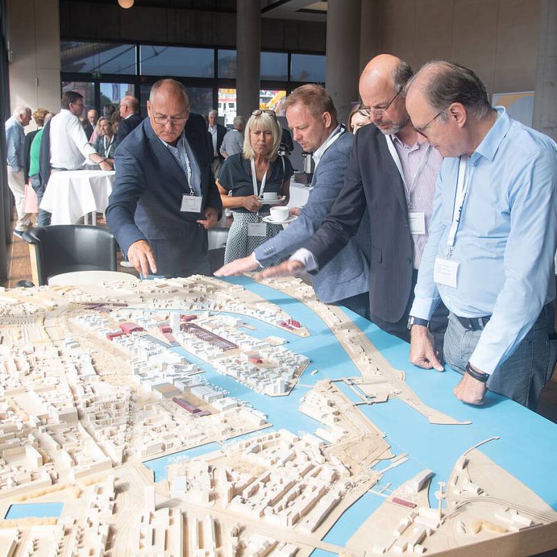 Unterschiedliche Männer die auf eine dreidimensionale Küstenkarte schauen