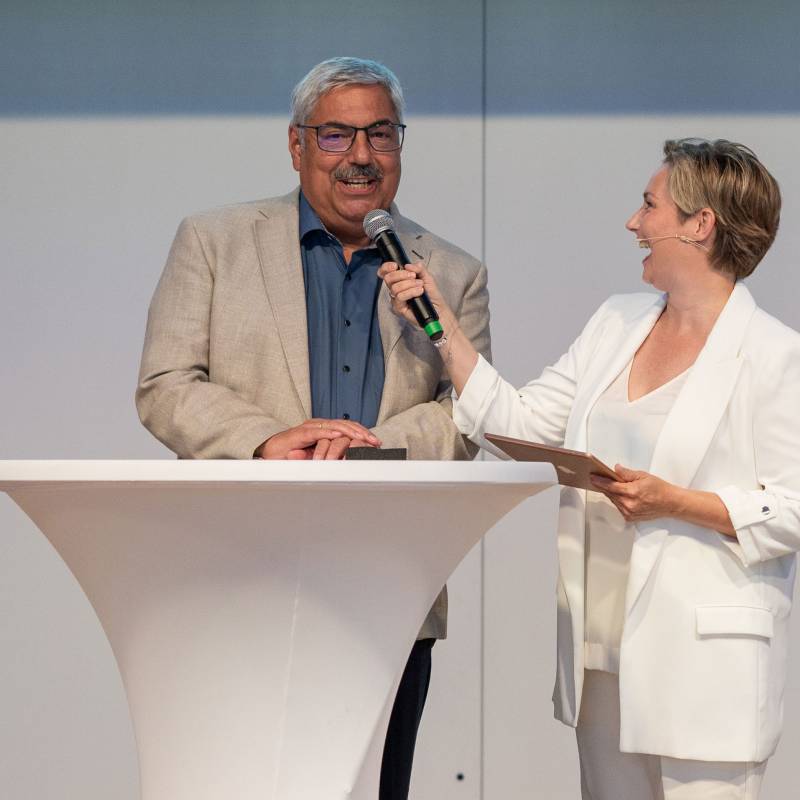 Oberbürgermeister der Stadt Bremerhaven Melf Grantz im Interview. Dargestellt ist ein Mann mittleren Alters mit weißen Haaren und eckiger Brille. Er wird gerade von einer Frau mit kurzen Haaren und einem Mikrophon in der Hand interviewt.